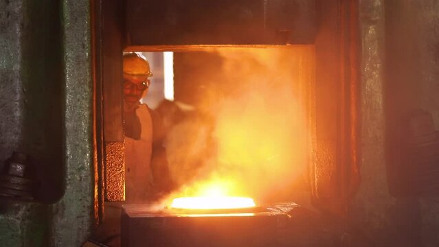 close up hot drop press forging metal piece shaping automatic drop hammer to give it tool shape. Open die forging hit by hammer on a tool cast to form a machine component part isothermal weld factory	