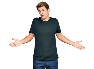 Handsome caucasian man wearing casual clothes clueless and confused expression with arms and hands...