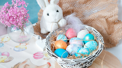 Easter eggs in a basket and toy rabbit. Easter composition. Holiday concept.