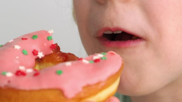 Take a bite of a delicious, fatty, high-calorie donut. The trendy dessert is the American donut. The donut is large in the mouth. National Donut Day in the USA. Healthy eating concept for children