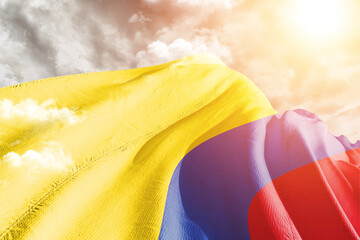Colombia national flag cloth fabric waving on beautiful cloudy Background.
