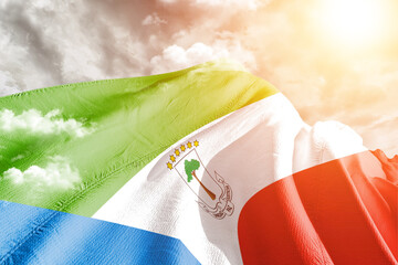 Equatorial Guinea national flag cloth fabric waving on beautiful cloudy Background. - Powered by Adobe