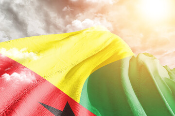 Guinea-Bissau national flag cloth fabric waving on beautiful cloudy Background.