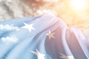 Micronesia, Federated States of Micronesia national flag cloth fabric waving on beautiful cloudy Background.