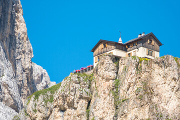 Typical mountain hut in the famous Dolomites mountain chain, Italy, close to the "Torri del Vajolet" (Vajolet rock towers). Blue sky on the background.