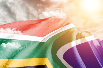 South Africa national flag cloth fabric waving on beautiful cloudy Background.
