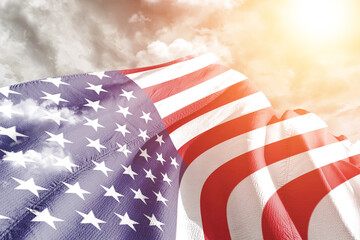 United States national flag cloth fabric waving on beautiful cloudy Background.