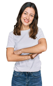 Young beautiful woman wearing casual white t shirt happy face smiling with crossed arms looking at the camera. positive person.