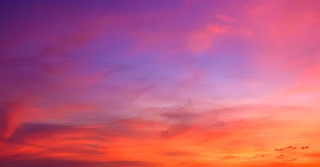 Poster Sunset sky background in the evening with colorful orange, pink, red, yellow sunlight and dramatic sunrise clouds on beautiful amazing twilight horizon sky  © Prapat