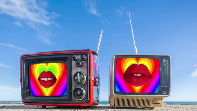 retro televisions with lips on the screen on a beach vertical