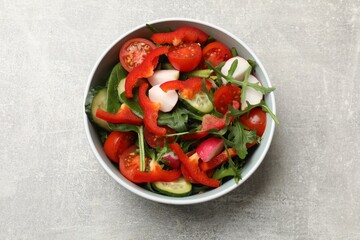 Tasty fresh vegetarian salad on light grey table, top view