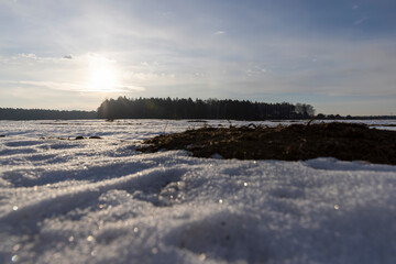 snow-covered plowed soil in the field in winter