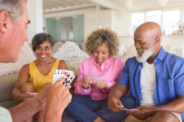 Group Of Mature Friends At Home Having Fun Playing Cards Together