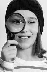 Portrait of student boy with magnifier. School, learning and development concept. Boy looking through magnifying glass.