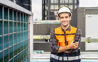 Portrait of male technical foreman in safety uniform inspects maintenance work holding radio call and smiling looking to the camera with to look at plumbing and electrical systems on the roof