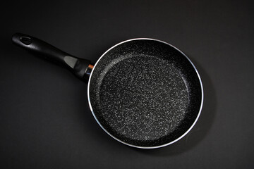 Metal frying pan: Ceramic coating with non-stick coating: Kitchen utensils; On a black background:...