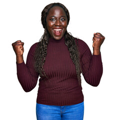 Young african woman wearing casual winter sweater celebrating surprised and amazed for success with...