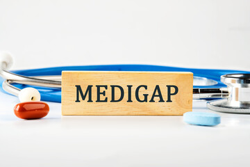 Medical concept. MEDIGAP on a wooden block on a gray background