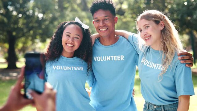 Community, smartphone and happy volunteer, people or charity workers in nature together for social media. Nonprofit, collaboration or diversity friends volunteering, society responsibility or picture