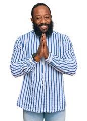 Young african american man wearing business shirt praying with hands together asking for forgiveness smiling confident.