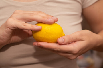 Fresh Lemons in female Hands. Close-up of fresh yellow lemons in a woman's hands.