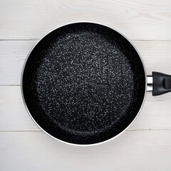 Metal Frying Pan:On a white, wooden insulated background. A place for the text.Ceramic coating with...