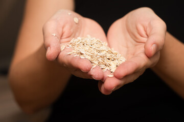 Holding a Bowl Full of Rolled Oats. Hands securely holding a bowl overflowing with whole rolled oats.