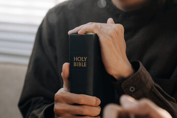 Christian man hands holding the holy bible to pray and worship God in the sunday...