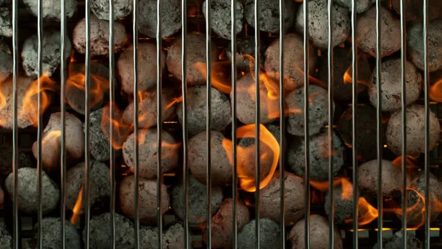 Super slow motion of burning charcoal on grill grid. Filmed on high speed cinema camera, 1000 fps. Top view.
