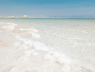 Landscape view on Dead Sea salt crystals formations, clear cyan green water at Ein Bokek beach,...