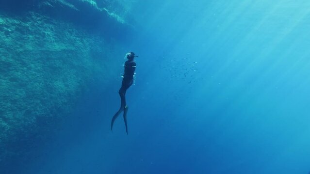 Underwater Slow Motion Footage of Free Diver Exploring Deep Ocean. Free Diving Recreation Sport.