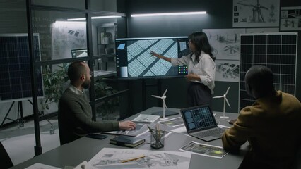 Full medium footage of Hispanic female renewable energy engineer presenting new model of solar panels for generating alternative sun energy to male diverse colleagues during office meeting - Powered by Adobe
