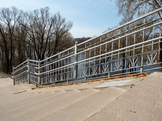Metal railing on the embankment of the river in the spring