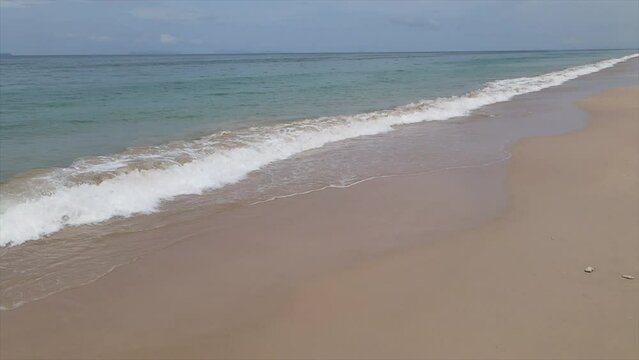 Slow motion video of sea waves and beautiful sandy beach of Koh Lanta, Krabi Province, Thailand, Asia.