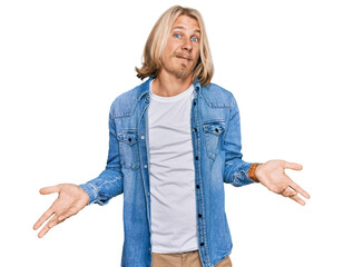 Caucasian man with blond long hair wearing casual denim jacket clueless and confused with open arms, no idea concept. - obrazy, fototapety, plakaty