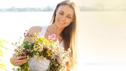 Portrait of a cute young woman with flowers. Summer holidays and active pastime in nature. Lifestyle of modern people.
