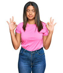 Young latin girl wearing casual clothes relax and smiling with eyes closed doing meditation gesture with fingers. yoga concept.