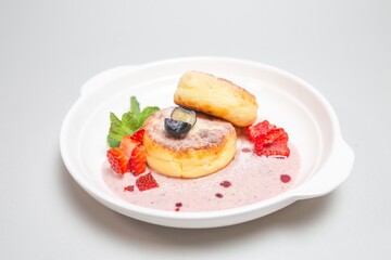 Freshly baked cottage cheese pancakes with berries on a plate