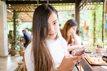 Beautiful casual business woman using smartphone internet connection sitting in cafe restaurant - 774858952