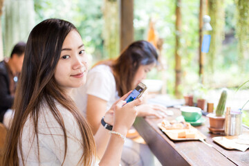 Beautiful casual business woman using smartphone internet connection sitting in cafe restaurant