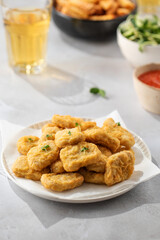 There is a plate of crispy chicken nuggets on the table. Fast food, fast food restaurant.
