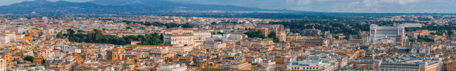 An aerial panorama of Rome shows terracotta rooftops and green canopies, blending ancient and modern architecture.