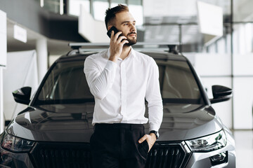 Man standing by the car and using mobile phone