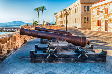 Disused cannons on the historic ramparts in Alghero, Sardinia, Italy - obrazy, fototapety, plakaty