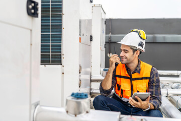 Male technical foreman inspects maintenance work holding a tablet and commands with talking on...