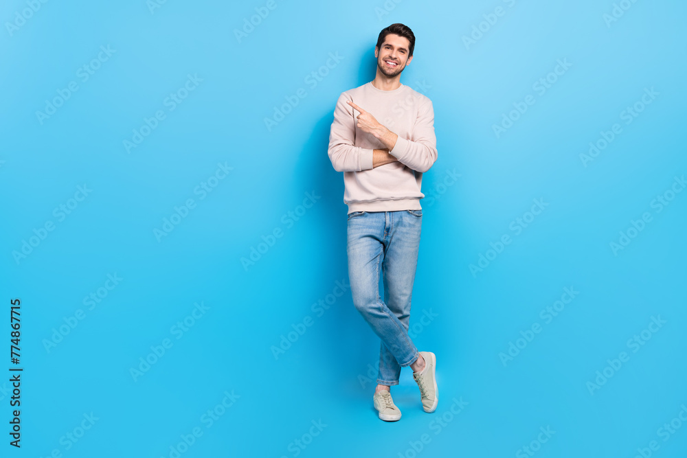 Poster full length photo of pretty cheerful guy dressed beige sweatshirt showing finger empty space isolate