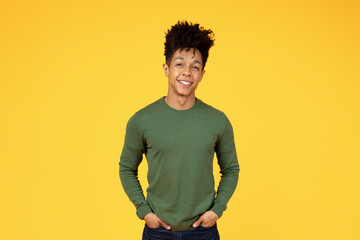 Young black man smiling on yellow background
