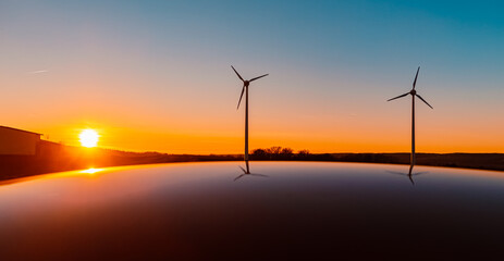 Sunset with wind turbine silhouettes and reflections on a car roof near Kugl, Simbach bei Landau,...