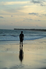 Naklejka premium silhueta de homem não identificado caminhando na Praia da lagoa do Pau (alagoas) ao amanhecer