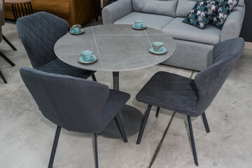 Gray wooden table combined with dark gray wooden chairs with soft fabric upholstery. There are blue...